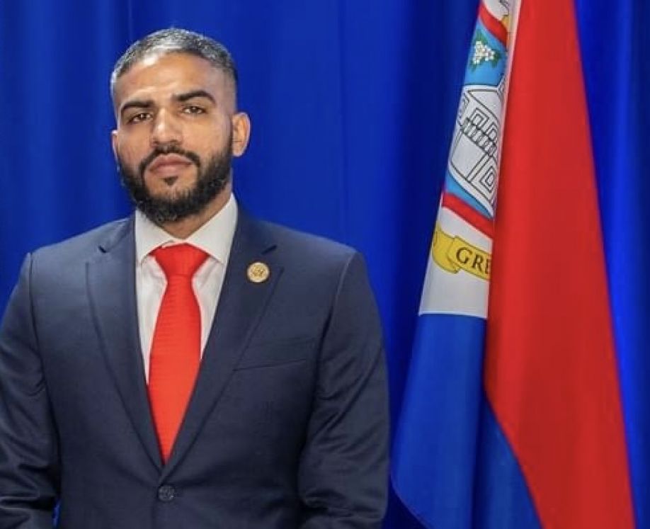 MP Viren V. Kotai in front of the flag of Sint Maarten, official portrait